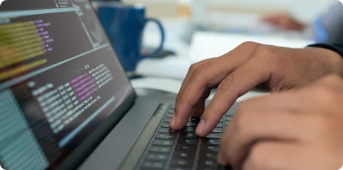 Hands typing on a laptop keyboard